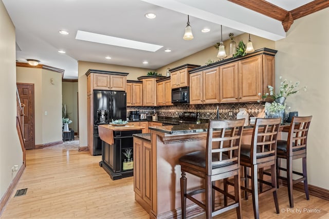 1913 N Woodlawn Park Ave, Mchenry, IL 60051 - kitchen with black appliances, a peninsula, backsplash, a skylight, and recessed lighting