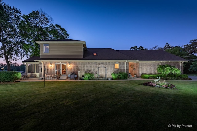 1913 N Woodlawn Park Ave, Mchenry, IL 60051 - view of front of house with brick siding, a front yard, and a patio area