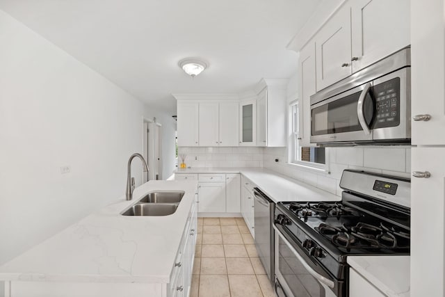 7004 W School St, Chicago, IL 60634 - kitchen featuring stainless steel appliances, tasteful backsplash, white cabinets, and light tile patterned floors