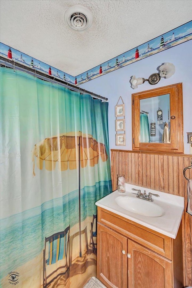 555/557 W Bluff St, Marseilles, IL 61341 - full bath with a textured ceiling, vanity, a wainscoted wall, and curtained shower