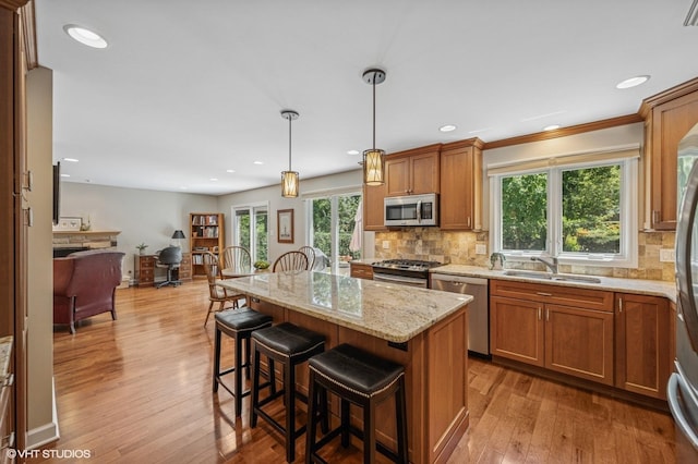 1355 W Kenilworth Ave, Palatine, IL 60067 - kitchen featuring appliances with stainless steel finishes, open floor plan, light stone countertops, a kitchen bar, and backsplash