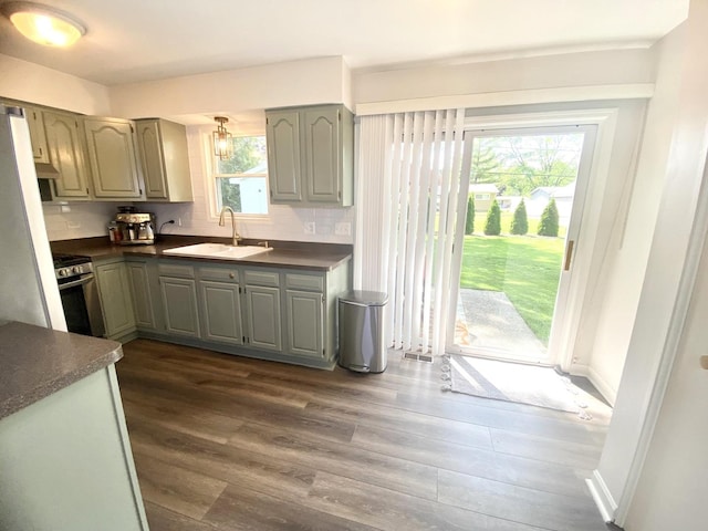 1615 Meadow Ln, Mchenry, IL 60050 - kitchen featuring dark countertops, gray cabinetry, stainless steel range, dark wood-style flooring, and backsplash