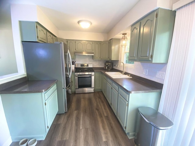 1615 Meadow Ln, Mchenry, IL 60050 - kitchen with stainless steel appliances, dark countertops, dark wood-style flooring, under cabinet range hood, and backsplash