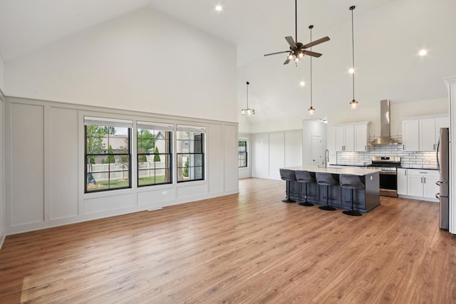 220 S Primrose Dr, Coal City, IL 60416 - unfurnished living room with a decorative wall, high vaulted ceiling, a ceiling fan, plenty of natural light, and light wood-type flooring