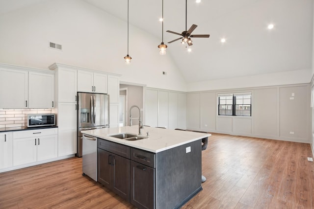 220 S Primrose Dr, Coal City, IL 60416 - kitchen featuring appliances with stainless steel finishes, high vaulted ceiling, white cabinetry, ceiling fan, and light wood-style floors