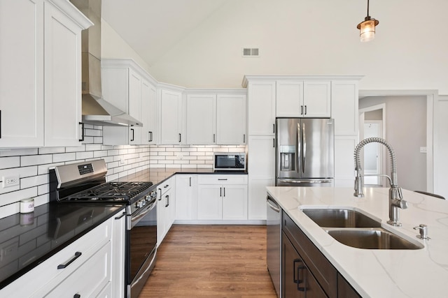 220 S Primrose Dr, Coal City, IL 60416 - kitchen featuring appliances with stainless steel finishes, wall chimney range hood, white cabinets, decorative backsplash, and high vaulted ceiling