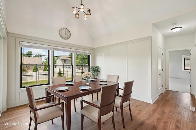 220 S Primrose Dr, Coal City, IL 60416 - dining space with a chandelier, light wood-style flooring, high vaulted ceiling, and a decorative wall