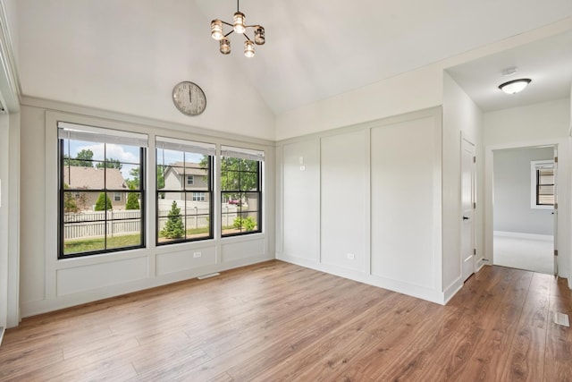 220 S Primrose Dr, Coal City, IL 60416 - unfurnished bedroom featuring a chandelier, light wood finished floors, a decorative wall, a closet, and high vaulted ceiling