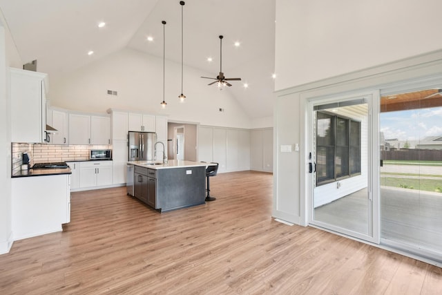 220 S Primrose Dr, Coal City, IL 60416 - kitchen featuring stainless steel fridge, white cabinetry, light wood-style floors, high vaulted ceiling, and a ceiling fan