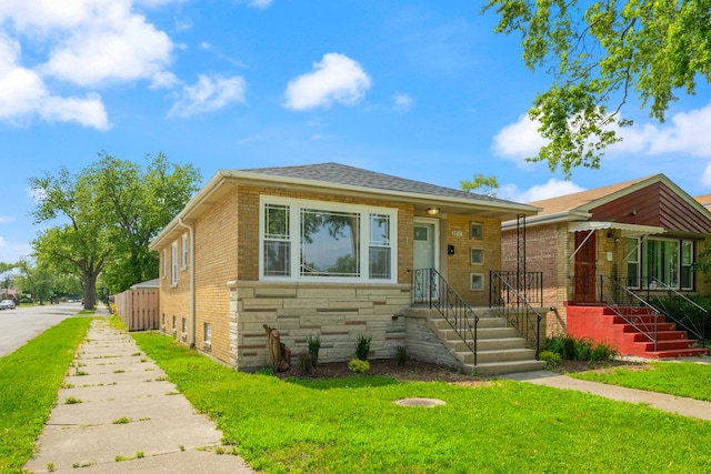 8858 S Calumet Ave, Chicago, IL 60619 - bungalow featuring a front yard, stone siding, and brick siding