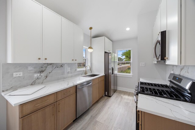 8858 S Calumet Ave, Chicago, IL 60619 - kitchen featuring appliances with stainless steel finishes, light wood finished floors, backsplash, white cabinetry, and light stone countertops