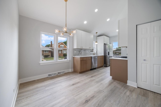 8858 S Calumet Ave, Chicago, IL 60619 - kitchen featuring stainless steel appliances, a chandelier, light countertops, white cabinetry, and light wood-type flooring