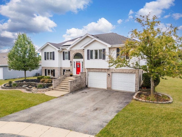 5147 Fairground Ct, Monee, IL 60449 - split foyer home with asphalt driveway, a front lawn, an attached garage, solar panels, and brick siding