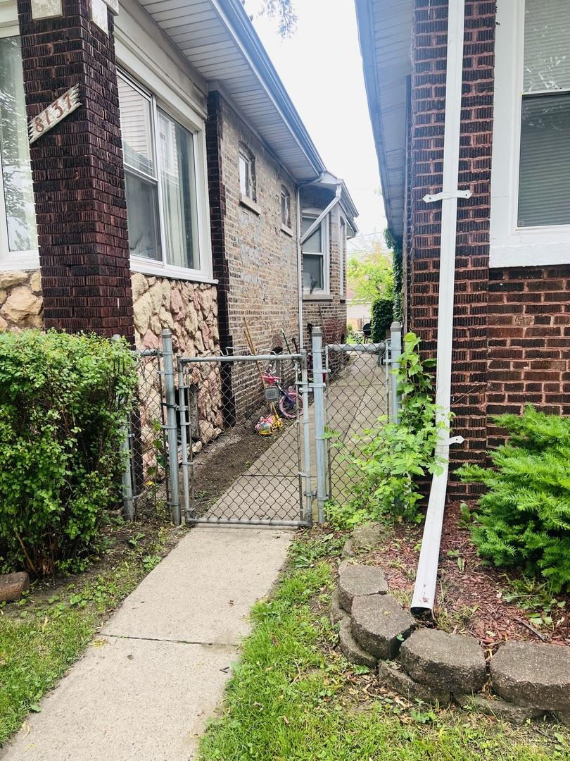 8137 S Bennett Ave, Chicago, IL 60617 - view of side of home with a gate, brick siding, and stone siding