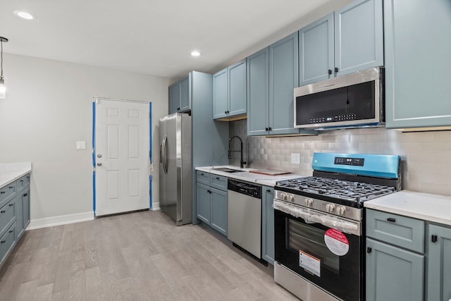 7711 S Ridgeland Ave, Chicago, IL 60649 - kitchen featuring appliances with stainless steel finishes, light wood finished floors, light countertops, tasteful backsplash, and recessed lighting