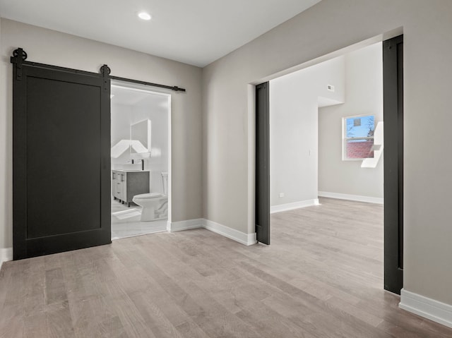 7711 S Ridgeland Ave, Chicago, IL 60649 - empty room with a barn door, wood finished floors, and recessed lighting