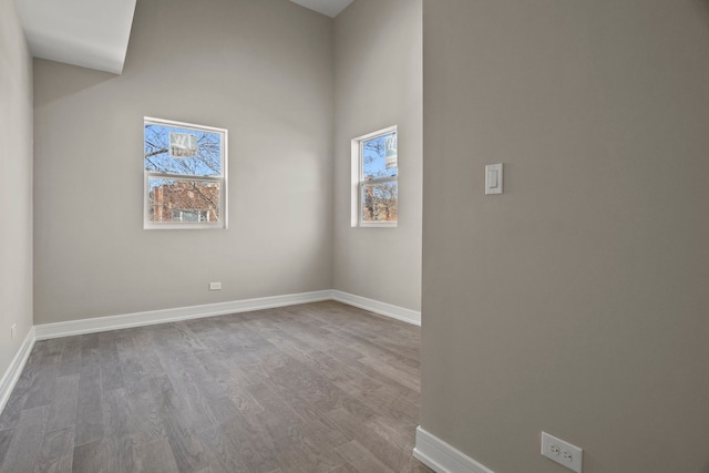 7711 S Ridgeland Ave, Chicago, IL 60649 - unfurnished room with wood finished floors, healthy amount of natural light, and a high ceiling