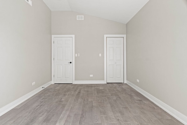 7711 S Ridgeland Ave, Chicago, IL 60649 - unfurnished bedroom featuring lofted ceiling and light wood-type flooring
