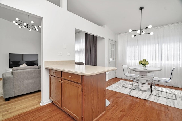 16636 Winding Creek Rd, Plainfield, IL 60586 - kitchen featuring a chandelier, light wood-style floors, light countertops, a peninsula, and hanging light fixtures
