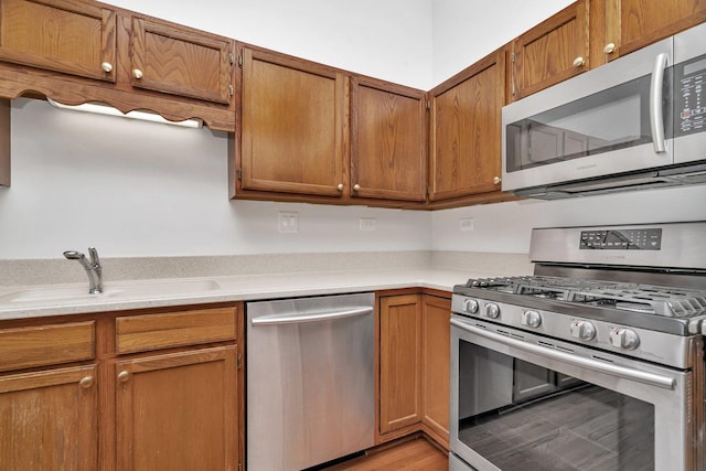 16636 Winding Creek Rd, Plainfield, IL 60586 - kitchen with stainless steel appliances, light countertops, brown cabinets, and light wood-style flooring
