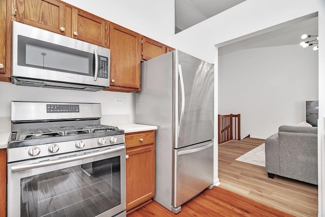 16636 Winding Creek Rd, Plainfield, IL 60586 - kitchen featuring stainless steel appliances, light wood-style flooring, light countertops, and brown cabinetry