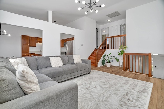 16636 Winding Creek Rd, Plainfield, IL 60586 - living area featuring a chandelier, light wood-type flooring, stairway, and lofted ceiling