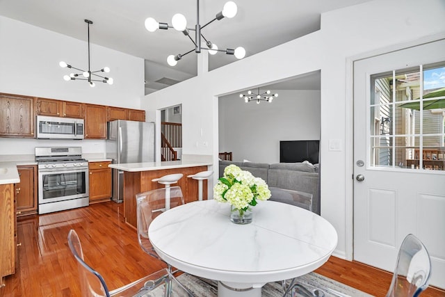 16636 Winding Creek Rd, Plainfield, IL 60586 - dining area with a chandelier, wood finished floors, and a towering ceiling