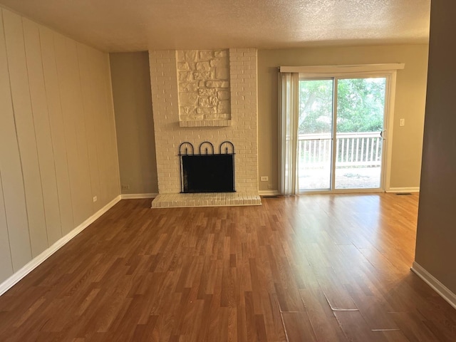 42 Pheasant Rd, Matteson, IL 60443 - unfurnished living room with wood finished floors, a brick fireplace, and a textured ceiling