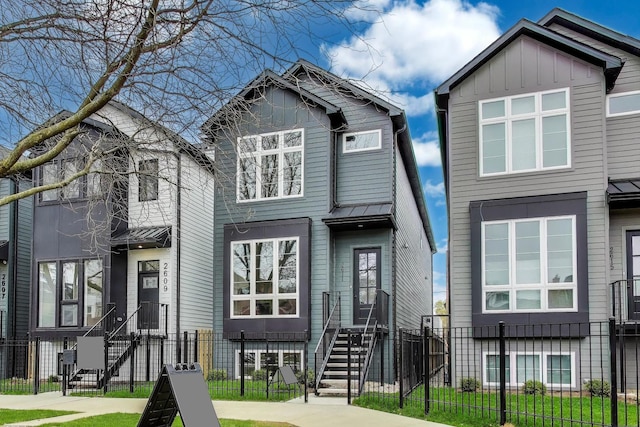 2611 W Carmen Ave, Chicago, IL 60625 - view of front of property featuring a fenced front yard, board and batten siding, a metal roof, and a standing seam roof