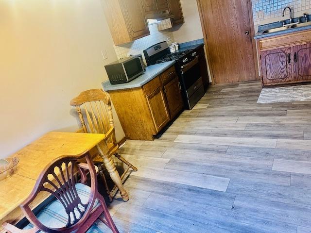 15800 S Laramie Ave Unit Q, Oak Forest, IL 60452 - kitchen featuring stainless steel appliances, light wood finished floors, decorative backsplash, and ventilation hood