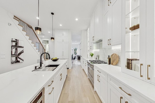 2607 W Carmen Ave, Chicago, IL 60625 - kitchen with high end stainless steel range, recessed lighting, white cabinetry, backsplash, and light wood-type flooring