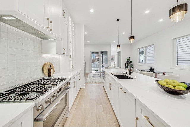 2607 W Carmen Ave, Chicago, IL 60625 - kitchen featuring stainless steel stove, custom exhaust hood, white cabinetry, decorative backsplash, and light stone countertops
