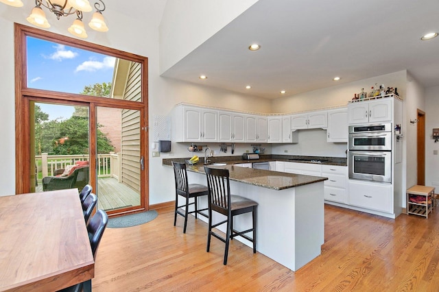 1521 Pendelton Ct, Palatine, IL 60067 - kitchen featuring stainless steel appliances, white cabinets, light wood-type flooring, a breakfast bar area, and recessed lighting