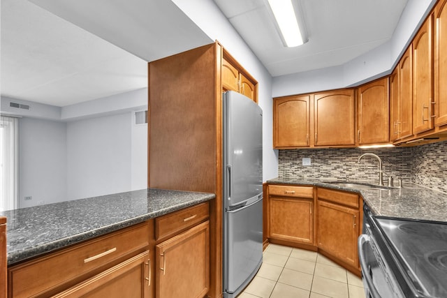 814 N River Rd Unit 1D, Mount Prospect, IL 60056 - kitchen featuring appliances with stainless steel finishes, tasteful backsplash, light tile patterned floors, and dark stone counters