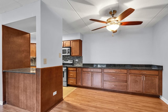 814 N River Rd Unit 1D, Mount Prospect, IL 60056 - kitchen with stainless steel appliances, light wood-style flooring, a ceiling fan, tasteful backsplash, and brown cabinetry