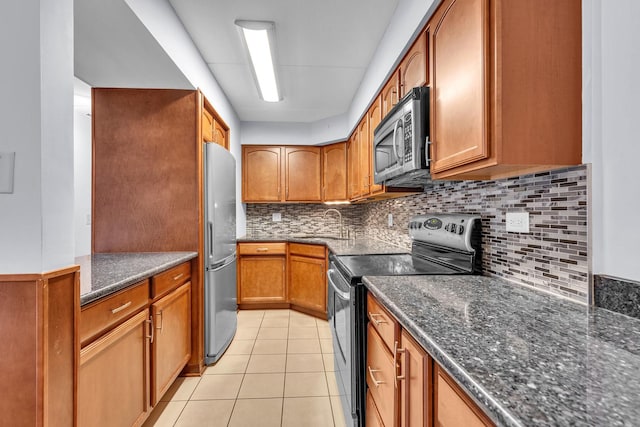 814 N River Rd Unit 1D, Mount Prospect, IL 60056 - kitchen with appliances with stainless steel finishes, dark stone counters, tasteful backsplash, light tile patterned floors, and brown cabinets