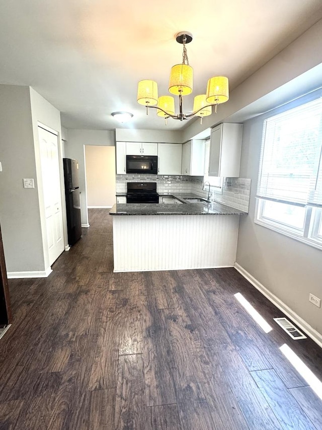 706 Carnation Ln, Matteson, IL 60443 - kitchen featuring black microwave, freestanding refrigerator, a peninsula, stove, and tasteful backsplash