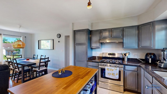 554 Foxford Rd, Bartlett, IL 60103 - kitchen featuring gas range, under cabinet range hood, dark stone countertops, and pendant lighting