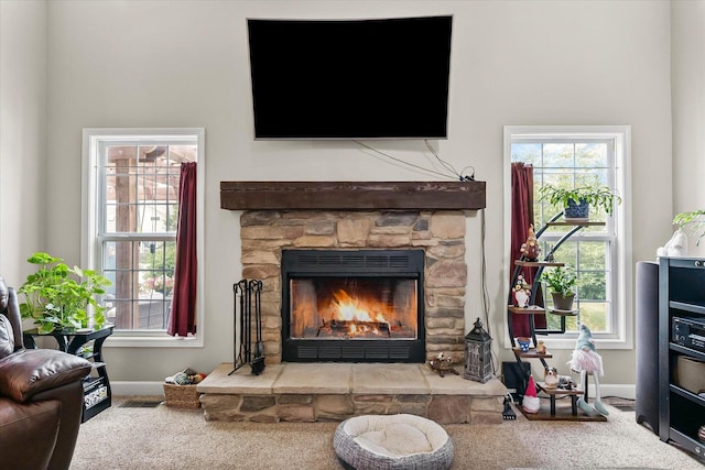 204 Campbell St, Tolono, IL 61880 - carpeted living room featuring a stone fireplace and baseboards