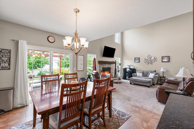204 Campbell St, Tolono, IL 61880 - dining area featuring light tile patterned floors, light carpet, a chandelier, and a fireplace