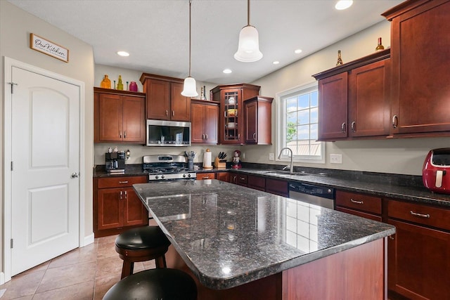 204 Campbell St, Tolono, IL 61880 - kitchen featuring stainless steel appliances, pendant lighting, glass insert cabinets, a kitchen island, and dark stone countertops