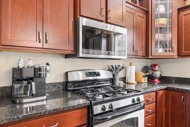 204 Campbell St, Tolono, IL 61880 - kitchen featuring stainless steel appliances, glass insert cabinets, and brown cabinetry