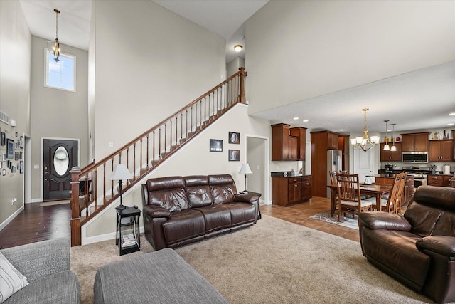 204 Campbell St, Tolono, IL 61880 - living area with a towering ceiling, a chandelier, stairs, and dark carpet