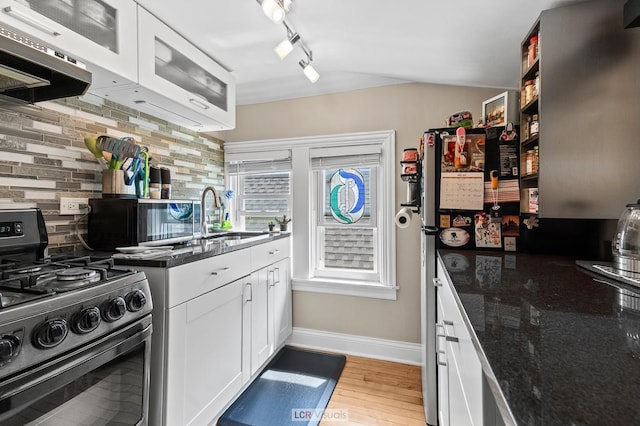 5128 W Carmen Ave, Chicago, IL 60630 - kitchen with stainless steel range with gas cooktop, white cabinetry, decorative backsplash, dark stone countertops, and light wood-style floors