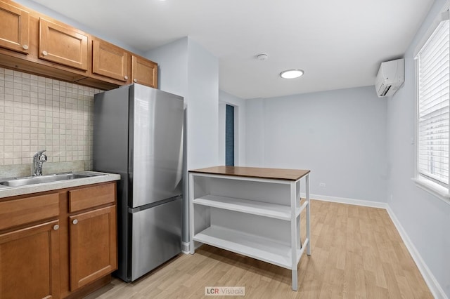 5128 W Carmen Ave, Chicago, IL 60630 - kitchen with freestanding refrigerator, a wall mounted AC, light wood-style flooring, and brown cabinets