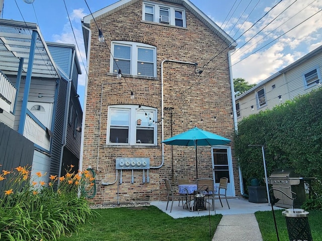 5128 W Carmen Ave, Chicago, IL 60630 - rear view of house with brick siding, a patio, and a yard