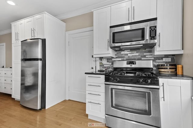 5128 W Carmen Ave, Chicago, IL 60630 - kitchen with stainless steel appliances, crown molding, light wood finished floors, dark countertops, and white cabinetry
