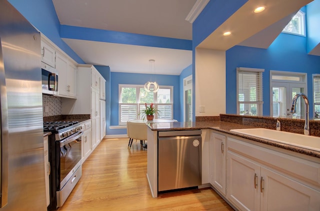 332 Stonemill Ln, Oswego, IL 60543 - kitchen with stainless steel appliances, light wood finished floors, white cabinetry, hanging light fixtures, and recessed lighting