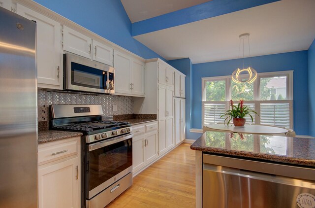 332 Stonemill Ln, Oswego, IL 60543 - kitchen with stainless steel appliances, tasteful backsplash, light wood-style flooring, white cabinetry, and dark stone counters