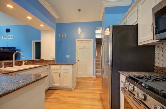 332 Stonemill Ln, Oswego, IL 60543 - kitchen with stainless steel appliances, light wood-style flooring, white cabinets, decorative backsplash, and crown molding